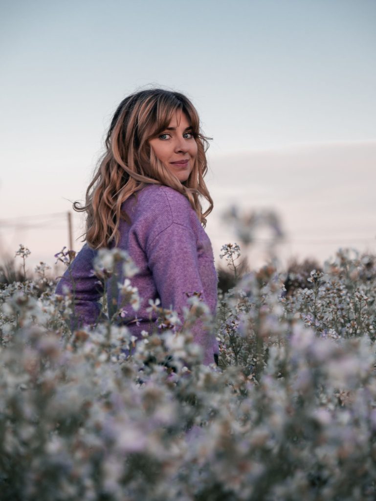 Océane naturopathe spécialisé endométriose dans un champ de fleurs blanche